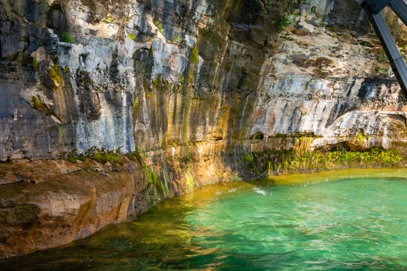 A body of water with green water and rocks.