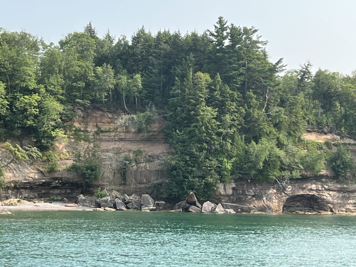 A body of water with trees and rocks in the background.